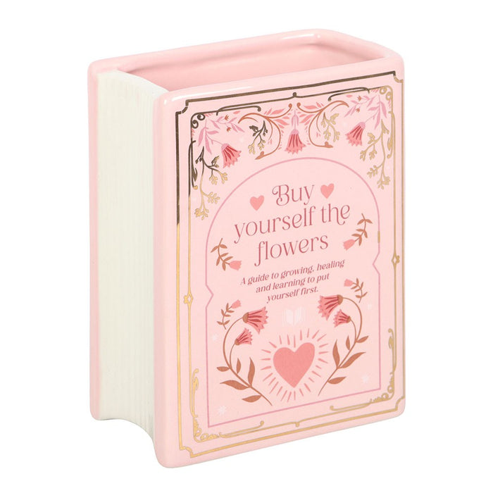 Upright pink book shaped vase with floral literary cover design