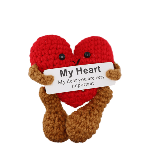Crochet red heart character with brown legs holding a My Heart message card on white background