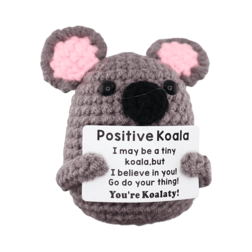 Grey crochet koala decoration with pink ears holding a you’re koalaty message card