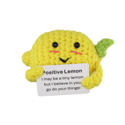 Bright yellow crochet lemon decoration holding a motivational message card on white background