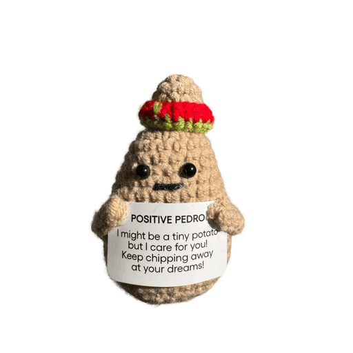 Crocheted Positive Pedro potato decoration wearing a colourful hat and holding a motivational message card on white background