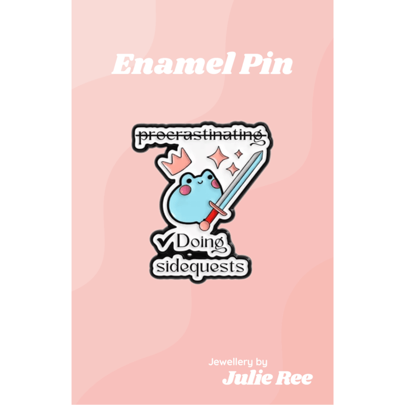 Cute blue frog enamel pin holding a sword with the text procrastinating doing sidequests