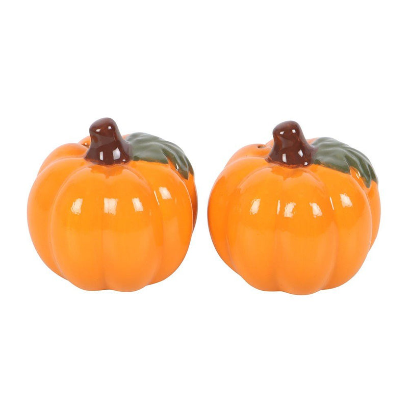 Side view of ceramic pumpkin shakers showing green leaf detail and brown stem tops.
