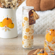Pumpkin-scented prayer candle styled on wooden table with autumn décor.

