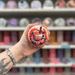 Pumpkin Spice wax melt pot held in hand with colourful wax melt display in the background
