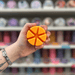 Pumpkin Spice wax melt segments held in hand with colourful wax melt display in the background
