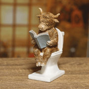 Lifestyle view of 15cm Highland cow bathroom figurine on a wooden surface, quirky home décor piece