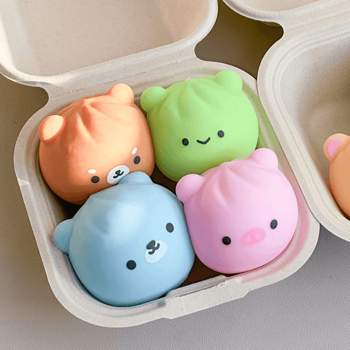 Assorted animal dumpling squishy toys displayed in a takeaway tray