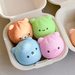 Assorted animal dumpling squishy toys displayed in a takeaway tray