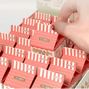 Hand picking a Random Cozy Cat milk-carton blind box from the display tray