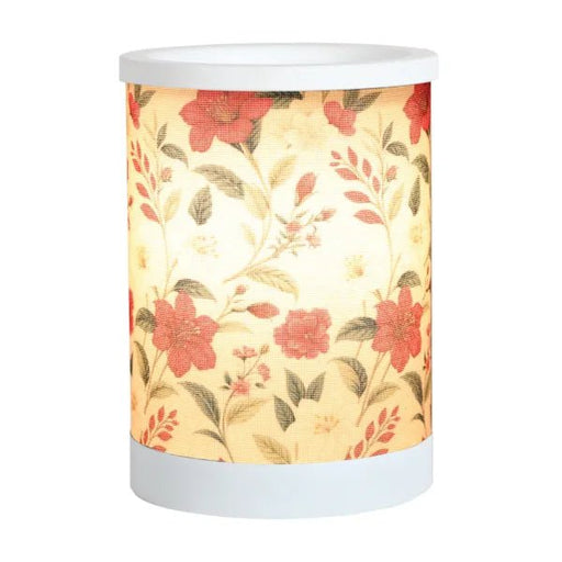Red floral electric wax melt burner switched on, glowing warmly through the floral design.