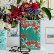 Romeo and Juliet ceramic book vase styled with flowers alongside an Alice in Wonderland book vase
