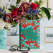 Romeo and Juliet ceramic book vase styled with flowers alongside an Alice in Wonderland book vase