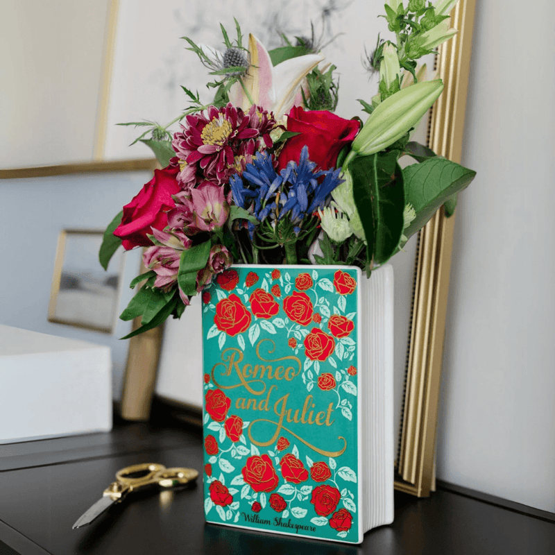 Romeo and Juliet ceramic book vase filled with flowers on a dressing table