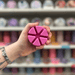 Rose Jam wax melt segments held in hand with colourful wax melt display in the background