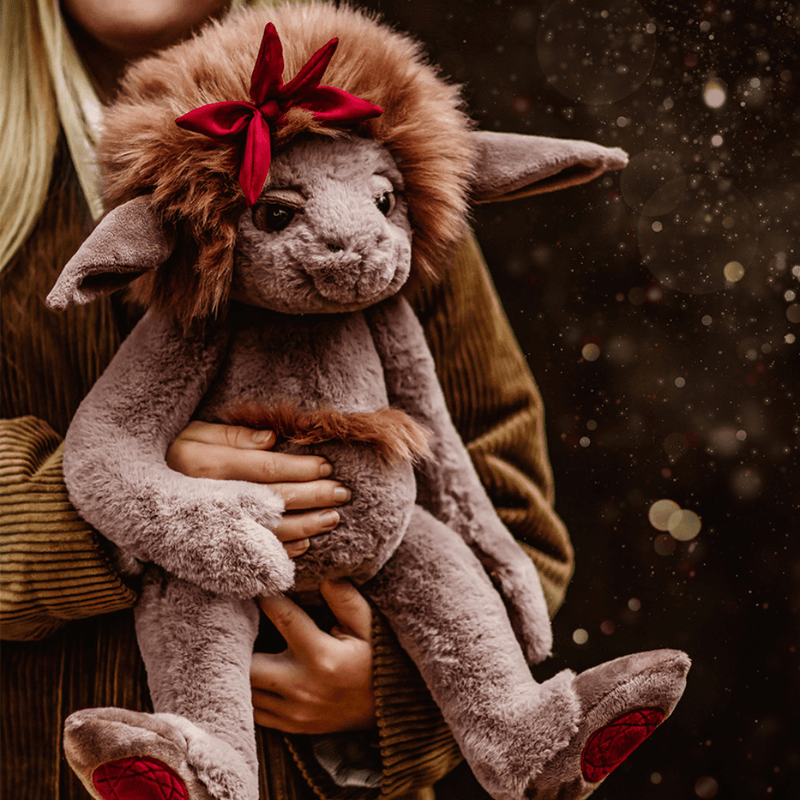 Ruby Roo Charlie Bears Bearhouse crystal troll plush being held outdoors, showing the fluffy mane, long ears and red crystal foot pads