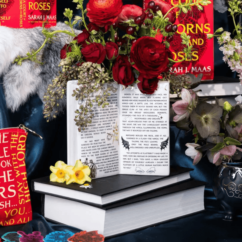 Sarah J Maas ACOTAR open book flower vase filled with red flowers on stacked books