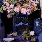 Sarah J Maas Velaris book flower vase filled with flowers in a Night Court display