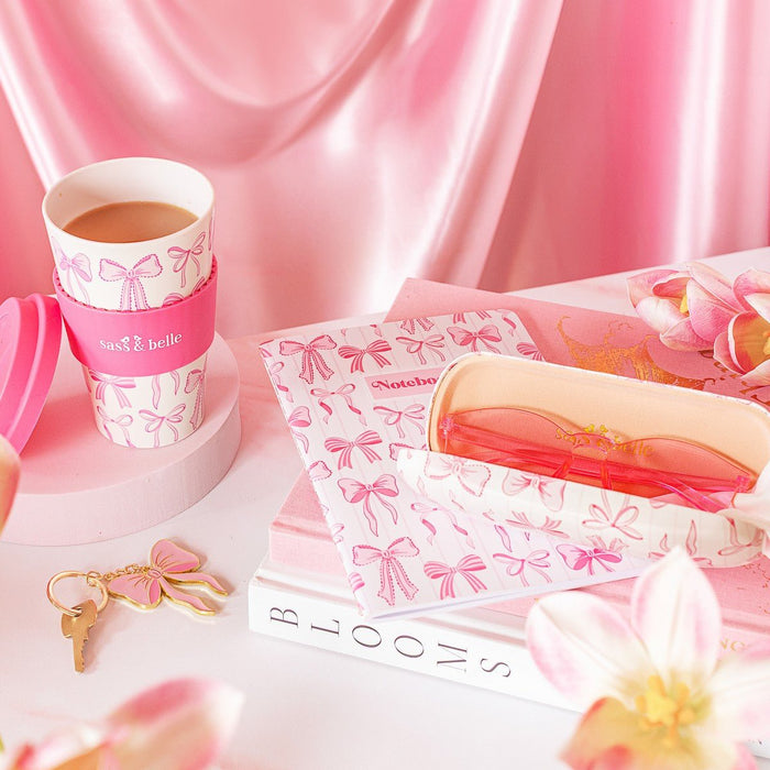 Sass & Belle bow travel coffee cup styled with bow stationery and pink accessories