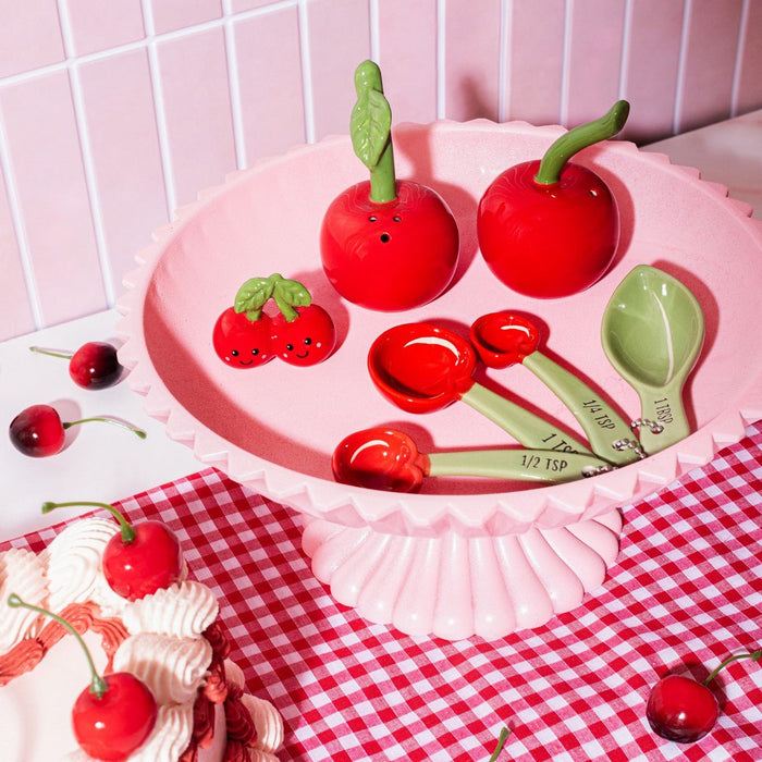 Sass & Belle cherry measuring spoons in a pink cake stand with matching cherry décor