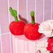 Close-up of Sass & Belle Cherry salt and pepper shakers, glossy red ceramic
