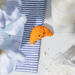 Smiling croissant pocket token in a kitchen-style lifestyle scene, orange dolomite mini token