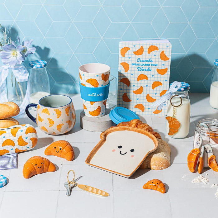 Croissant travel coffee cup by Sass & Belle styled with breakfast items and croissant-themed gifts