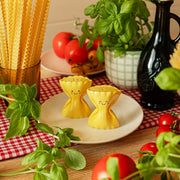 Sass & Belle pasta farfalle salt and pepper shakers on a plate with herbs and tomatoes