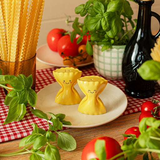 Sass & Belle pasta farfalle salt and pepper shakers on a plate with herbs and tomatoes