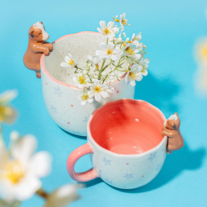 Coral Peeking Goat Mug shown in a bright lifestyle scene with flowers and matching ceramics