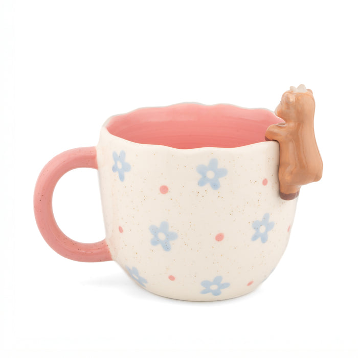 Side view of the coral Peeking Goat Mug showing the scalloped rim, floral details and goat character