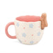Side view of the coral Peeking Goat Mug showing the scalloped rim, floral details and goat character