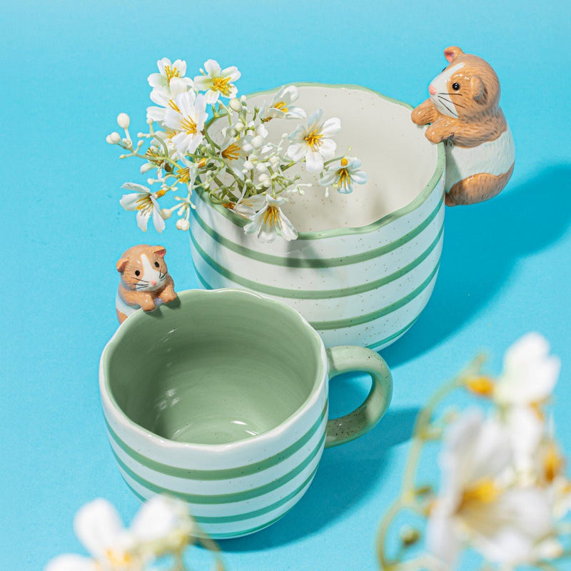 Green striped Peeking Guinea Pig Mug in a bright lifestyle scene with flowers and a matching mug