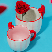 Sass and Belle Peeking Lobster mug styled with a red rose, showing the playful lobster detail and pink striped design