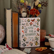 Sense and Sensibility book vase styled with dried flowers on a cosy desk beside classic books.