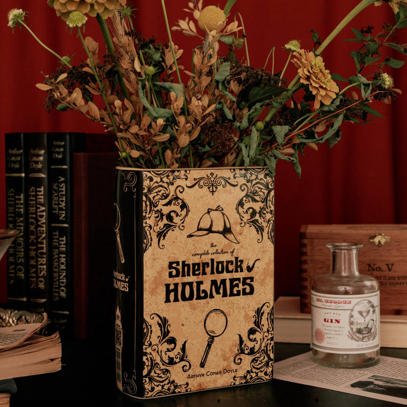 Sherlock Holmes book vase styled with dried flowers on a moody desk scene.