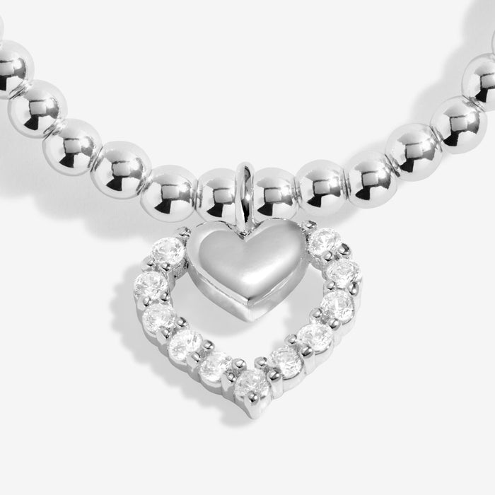 Close-up of Joma Jewellery heart halo charm with crystal-style stones on a silver-plated beaded Bracelet.