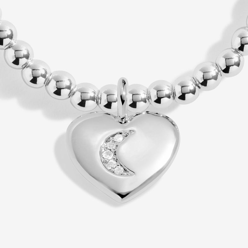 Close-up of Joma Jewellery heart charm with crescent moon crystal detail on a silver-plated beaded Bracelet.