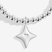 “Close‑up of silver four‑point star charm with tiny heart on beaded bracelet”
