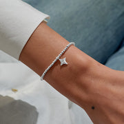“Silver beaded bracelet with four‑point star charm worn on wrist – lifestyle close‑up”
