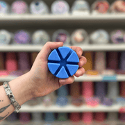 Sirens of the Sea wax melt segments held in hand with colourful wax melt display in the background