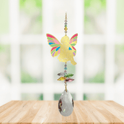 Sitting Fairy confetti Window Jewels crystal suncatcher hanging in a bright window, mirror-gold fairy motif with colourful crystals and clear drop.