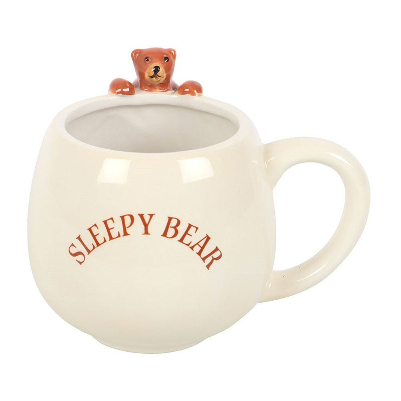 Front view of rounded ceramic Sleepy Bear mug showing text and bear peeking out.
