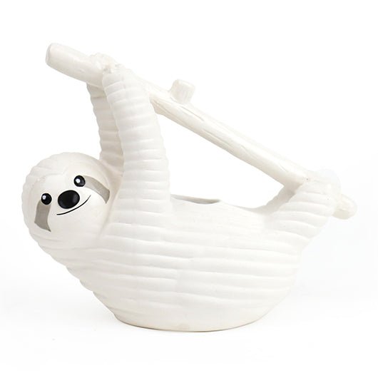 White ceramic sloth chia planter hanging from a branch on a plain white background