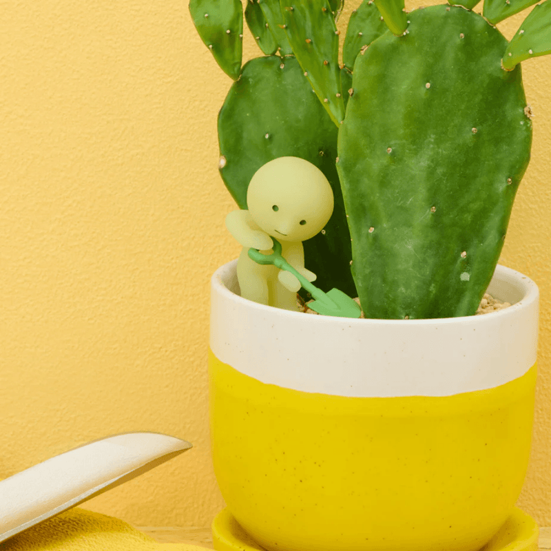 Smiski Construction figure digging beside a plant