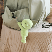 Smiski Hanging On plush keyring attached to a green backpack