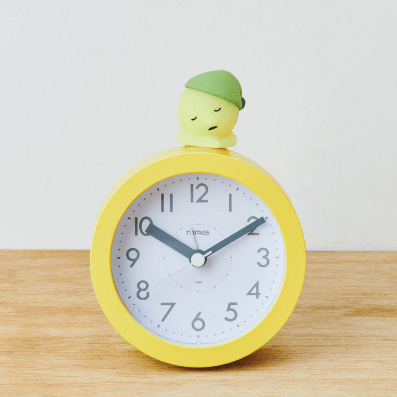 Smiski Dozing Hipper resting on an alarm clock