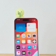 Smiski Hipper attached to the top of a smartphone