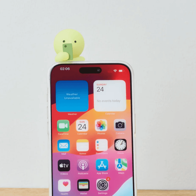 Smiski Hipper attached to the top of a smartphone