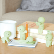 Smiski Living Series glow-in-the-dark figures displayed with books and stationery